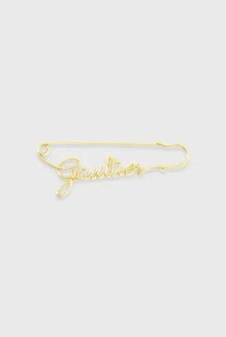Die goldfarbene Gaultier-Anstecknadel